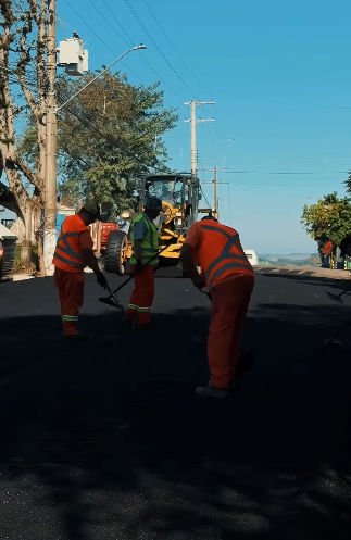 Equipe realizando o capeamento asfáltico na Rua 3 de Outubro